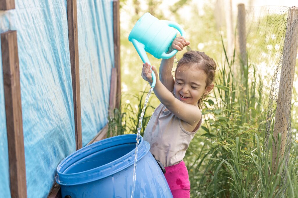 a-girl-of-two-years-old-watering-plants-in-a-count-2025-01-09-02-13-04-utc