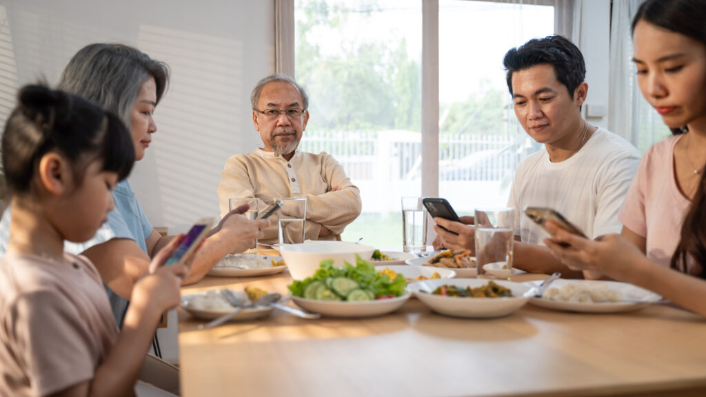 asian-addicted-family-use-mobile-phone-while-eatin-2025-03-24-09-40-43-utc everyone on their phone while eating a meal