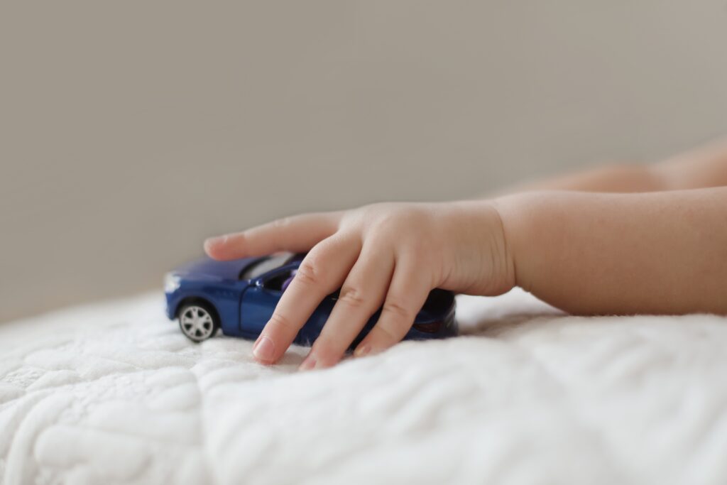 close-up-of-child-hand-playing-with-toy-car-indoor-2025-01-07-10-33-05-utc hand of child playing car