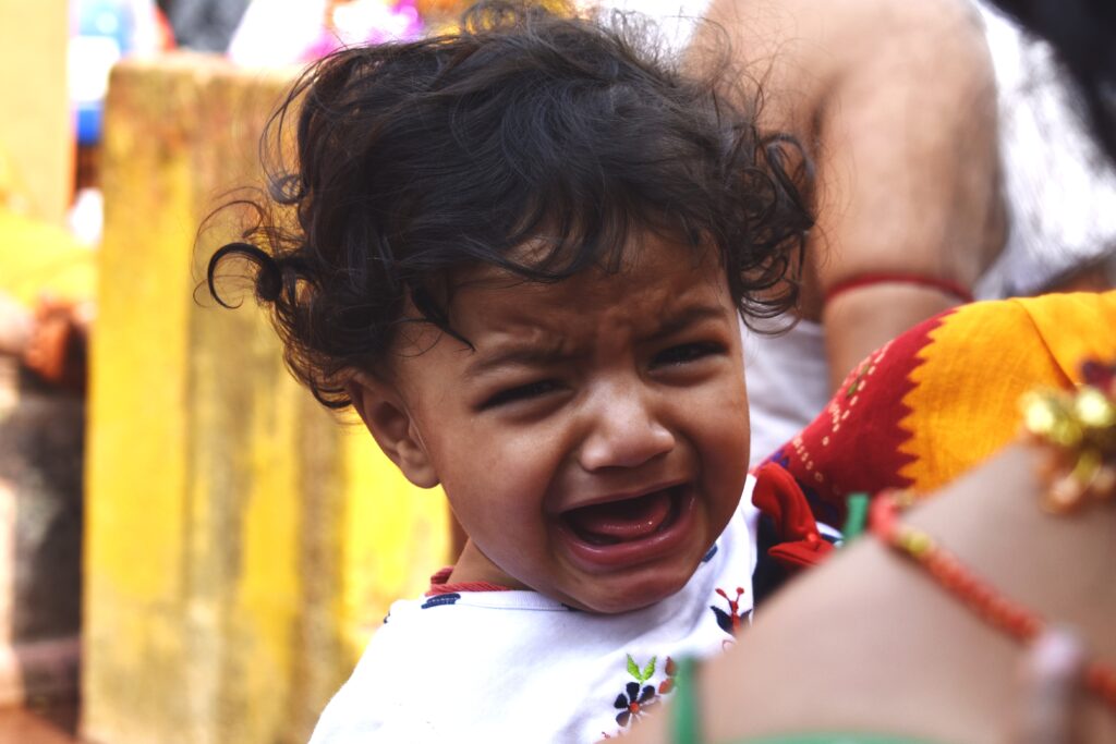 Portrait of a crying south asian little girl child getting irritated in the heat