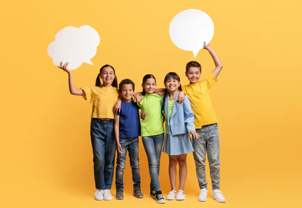 group of children holding speech bubble cards