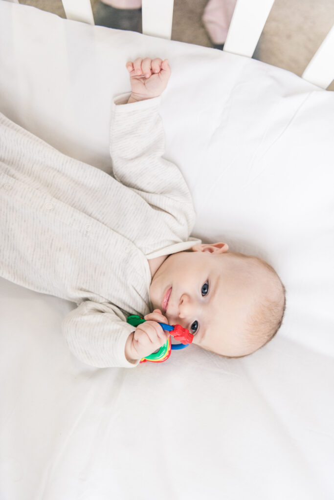overhead view of adorable baby with toy in crib baby holding a toy