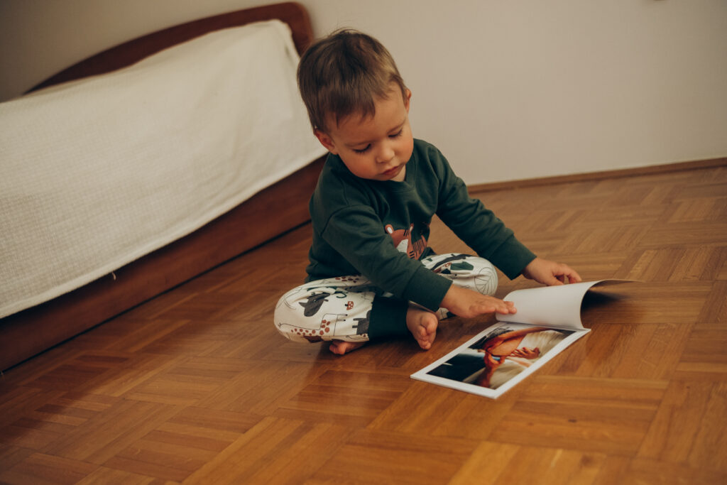 portrait-of-a-child-2-3-years-old-sitting-on-the-f-2025-01-07-18-20-45-utc child trying to read a book