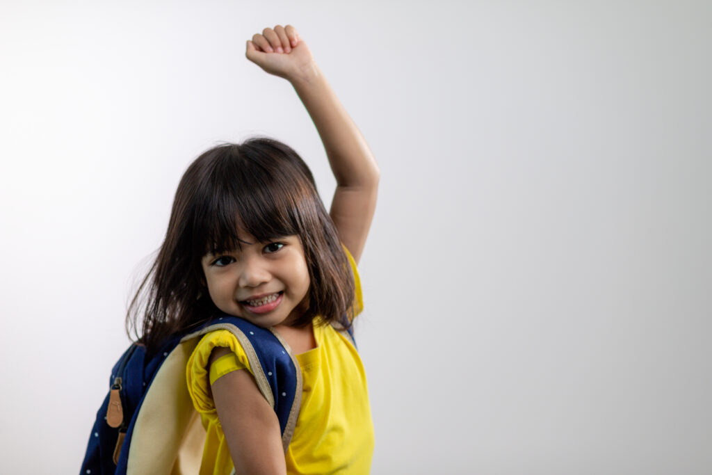 Asian young girl showing her arm with yellow bandage after got young girl happy after school